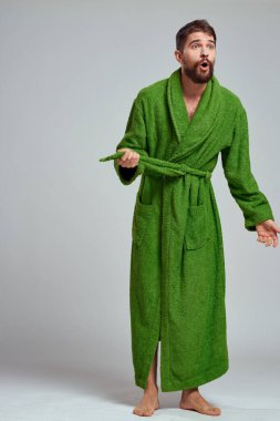 Yeşil cüppeli duygusal bir adam açık bir arkaplanda gelişen eğlenceli duygular modelinde.