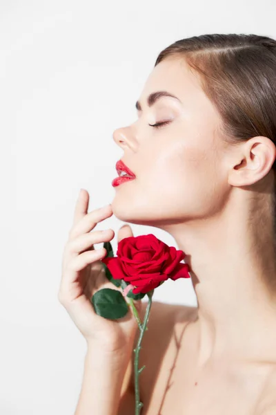 Donna con rosa annusa un fiore con gli occhi chiusi trucco luminoso — Foto Stock