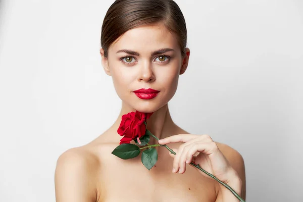 Kobieta z różą gołe ramiona, czysta skóra luksusowe światło — Zdjęcie stockowe