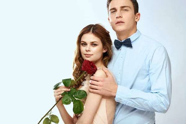 Mladý pár romantika objetí vztah datování červená růže světlo studio pozadí — Stock fotografie