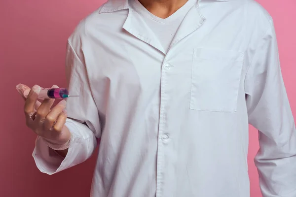 Un médecin portant un masque médical et des gants tient une seringue dans les mains d'un laboratoire d'injection — Photo