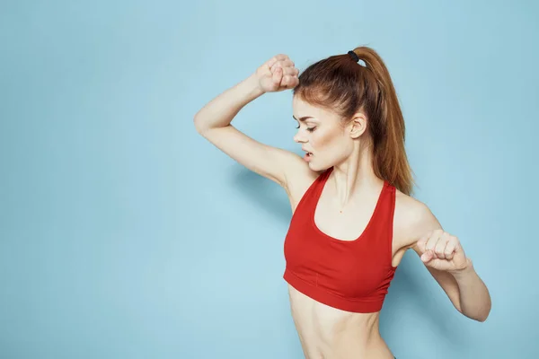 Donna sportiva serbatoio rosso allenamento stile di vita palestra sfondo blu — Foto Stock