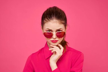 Pembe gömlekli ve kahverengi gözlüklü kadın kırpılmış görünüm modeli duyguları el hareketleriyle resim yapıyor.