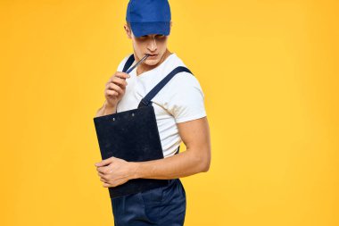 Çalışan üniformalı bir adam servis servisi sarı arka planını sunuyor.