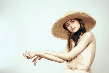 Şapkalı ve arka planda giyinmiş romantik bir kadın elleriyle komik duyguların portresini çiziyor.