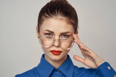 Mavi gömlekli ve gözlüklü duygusal kadın portresi parlak makyaj modeli arka plan kırpılmış görünüm kopyala