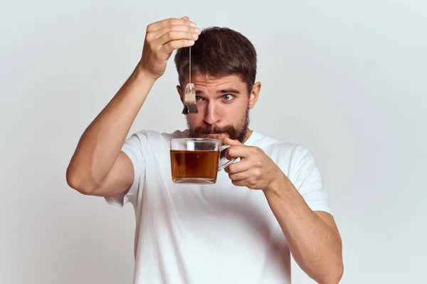 Homme avec une tasse de thé dans un sac sur un fond clair Boisson chaude recadrée modèle — Photo