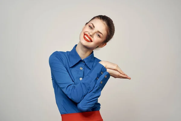 Une élégante dame en chemise bleue fait un geste avec ses mains sur un fond clair et un portrait en gros plan de l'espace de copie — Photo