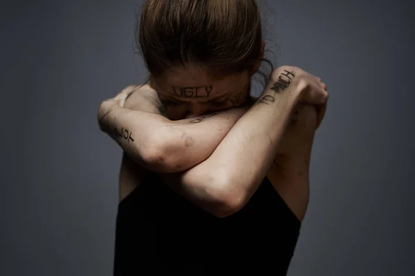Mujer con inscripciones ofensivas en su cuerpo tocándose con las manos estrés frustración odio — Foto de Stock