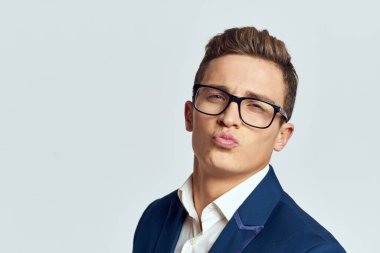 Gözlüklü bir iş adamı mavi takım elbiseli resmi ışık arkaplanı kesmiş.