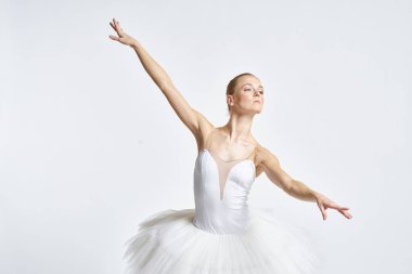 Beyaz etekli balerin dans egzersizi yapıyor. Esnek arka plan.