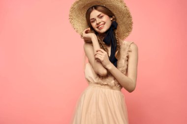 Şapkalı ve siyah kurdeleli güzel bir kadın. Pembe arka plan modeli.