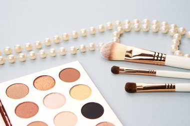 Göz makyajı fırçaları, gri arkaplandaki profesyonel kozmetik aksesuarları koleksiyonu.