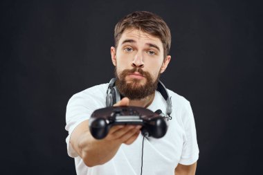 Elinde joystick olan bir adam kulaklıklar teknoloji eğlence oyun yaşam tarzı karanlık izole arka plan