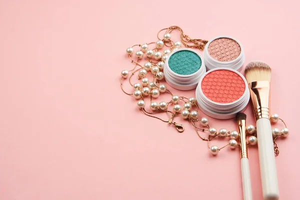Accesorios de sombra de ojos perlas maquillaje cepillos colección cosméticos profesionales sobre fondo rosa — Foto de Stock