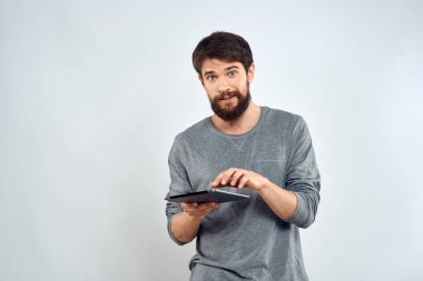 Gri kazaklı bir adam duyguların elinde bir tablet İnternet teknolojisi yaşam tarzı hafif arka plan