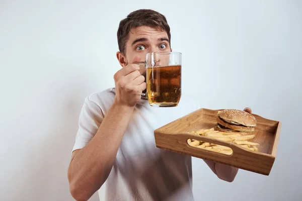 Homme avec plateau en bois tasse de bière frites et hamburger fast food calories modèle t-shirt blanc — Photo