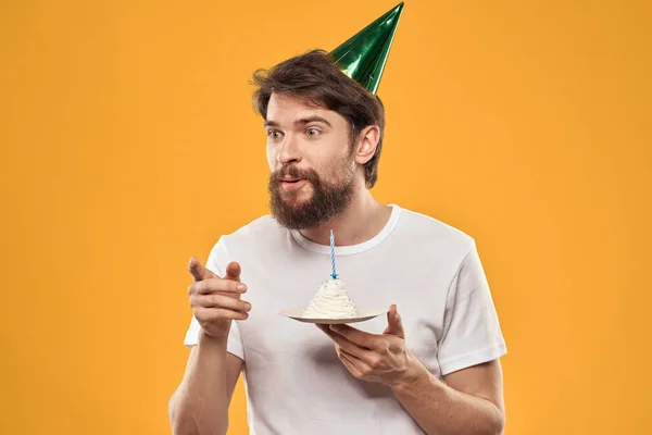 케이크를 들고 모자를 쓰고 생일을 축하하는 수염을 기른 남자 — 스톡 사진
