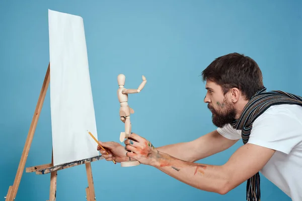 Maschio artista con un manichino di legno in mano disegno Creativo hobby sfondo blu — Foto Stock