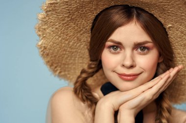 Hasır şapkalı kız portresi yakın çekim at kuyruğu eğlenceli kızıl saçlı mavi arka plan