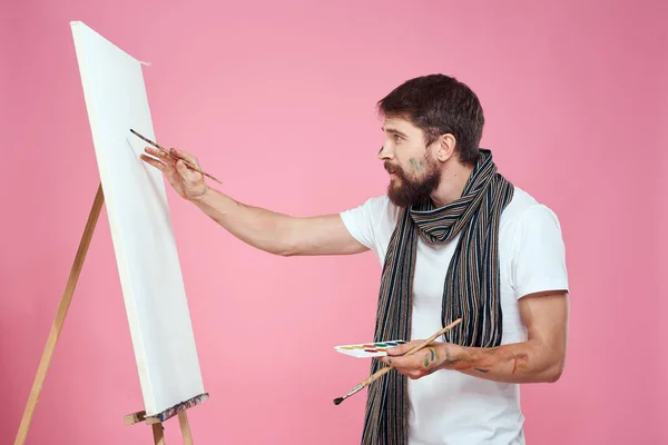 Ressam palet tutuyor sanat sehpası çiziyor yaratıcılık hobisi pembe arka plan — Stok fotoğraf