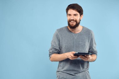 Kablosuz bir cihazın elinde tableti olan duygusal bir adam internet teknolojisi yaşam tarzı mavi arka plan