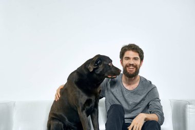 Kanepede evcil köpeği olan bir adam. Arkadaşlarıyla eğleniyor.