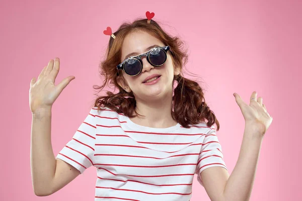 Chica alegre con coletas gafas de sol rayas camiseta estilo de vida rosa fondo — Foto de Stock