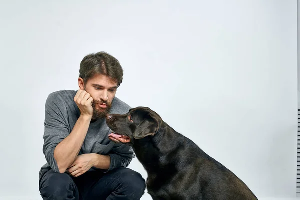 Feliz propietario con mascota negro perro entrenamiento modelo emociones — Foto de Stock