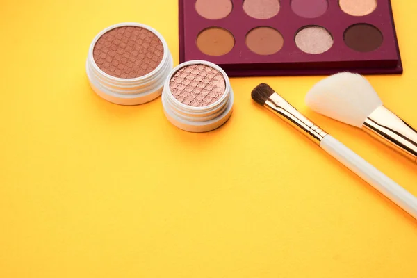 Sombras profesionales y pinceles de maquillaje sobre un fondo amarillo decoración de maquillaje —  Fotos de Stock