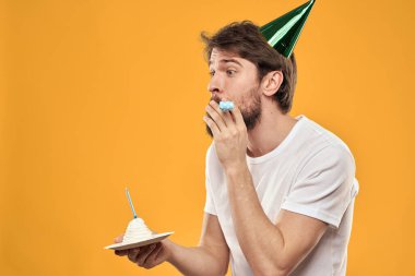 Pastalı sakallı ve şapkalı bir adam doğum gününü kutluyor.