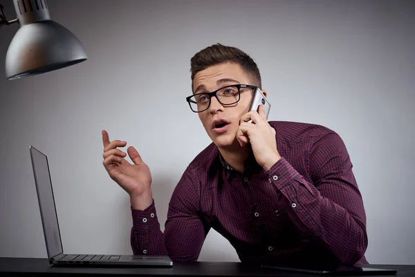 Homem de negócios em óculos e uma camisa senta-se a uma mesa com laptops abertos Coffee Space telefone móvel — Fotografia de Stock