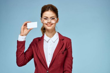 İş kadını kırmızı ceketli, gözlüklü, yönetici mavi arka planlı.