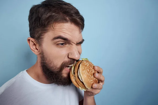 Emotionale Mann Hamburger Fast Food Diät Nahrung Nahaufnahme blauer Hintergrund — Stockfoto