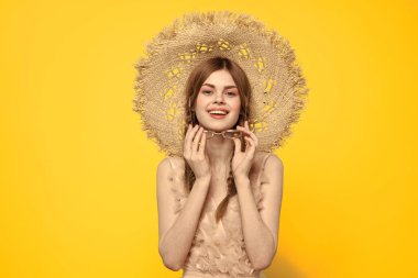 Hasır şapkalı duygusal kız ve sarı arka planda kırmızı örgülü bir elbise.