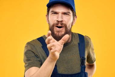 Üniformalı işçi, sarı arkaplan duygusuna hizmet ediyor.