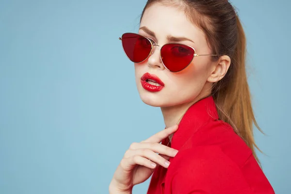 Mooie vrouw in donker bril heldere make-up rode lippen glamour blauwe achtergrond — Stockfoto
