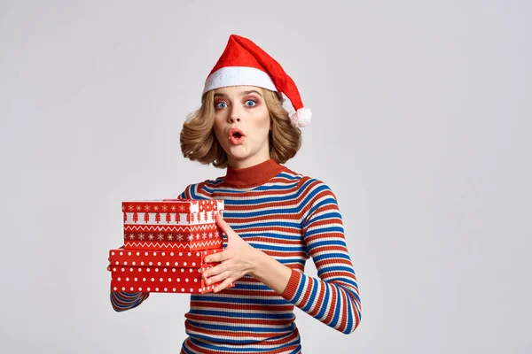 Glückliche Frau mit Weihnachtsgeschenken in den Händen und rotem Hut auf dem Kopf Neujahrsferien beschnitten Ansicht — Stockfoto