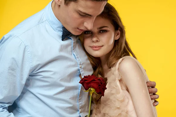 Homem e mulher com flor vermelha no fundo amarelo laço modelo corte vista — Fotografia de Stock