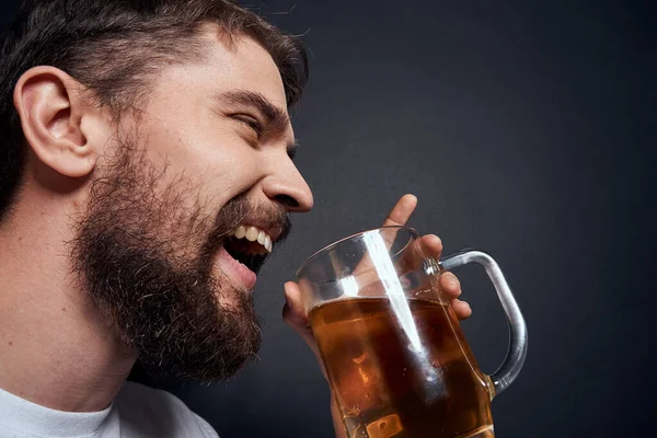 Mann mit einem Becher Bier im weißen T-Shirt Emotionen Lebensstil betrunken auf dunklem Hintergrund — Stockfoto