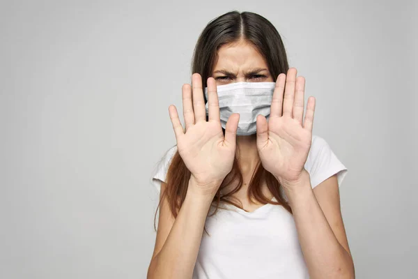 Mujer en una máscara médica sostiene sus manos frente a su estilo de vida de salud —  Fotos de Stock