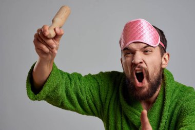 Elinde merdane olan adam yeşil cübbe pembe uyku maskesi kırpılmış manzara