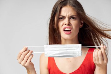 Elinde tıbbi maske olan kızgın bir kadın yüz ifadesinden hoşlanmadı. 