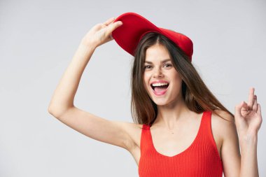 Kafasına şapka takmış neşeli bir kadın. Kırmızı tişört, gülümse. 