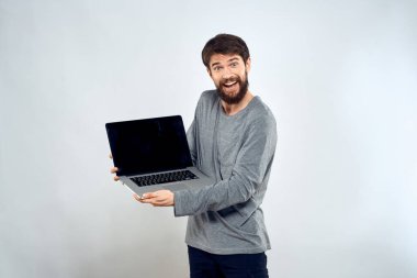 Gri kazaklı bir adam dizüstü bilgisayarlı. Yaşam tarzı teknoloji iletişimi internet işi yapıyor.