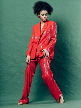 Kırmızı parlak kostümlü güzel kadın yalın ayak takıyor. 