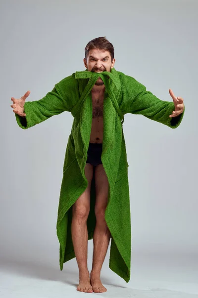 Эмоциональный человек в зеленом халате на светлом фоне в полный рост весело модель эмоций — стоковое фото