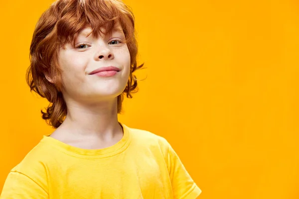 Pojke ler på en gul bakgrund närbild — Stockfoto