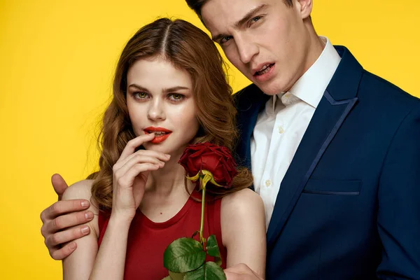 Pár v lásce muž a žena s červenou růží klasický kostým červené šaty model — Stock fotografie