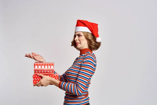 Szczęśliwa kobieta z prezentów świątecznych w rękach i czerwony kapelusz na głowie Nowy rok wakacje przycięte widok — Zdjęcie stockowe